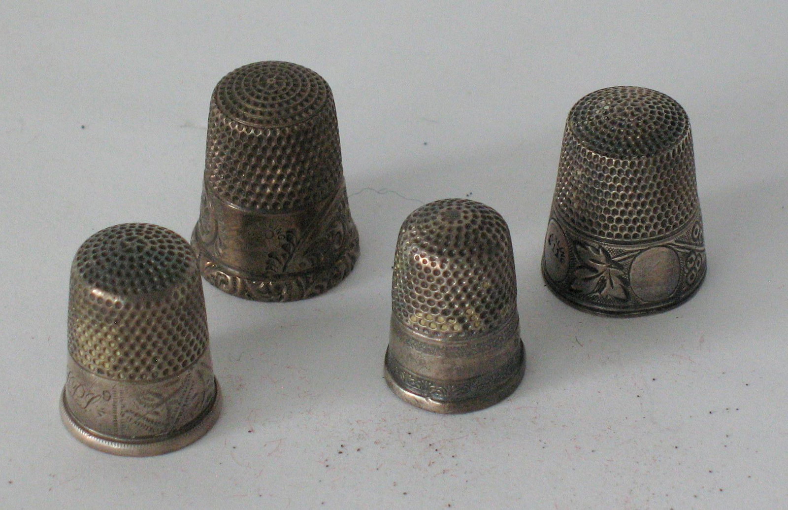 Group of early thimbles: Title: Group of early thimbles Date/Period: 1900's Dimension: About 3/4" each Additional Information: Group of 4 early thimbles, some with initials. Perhaps silver??? Great original condition. Shippin