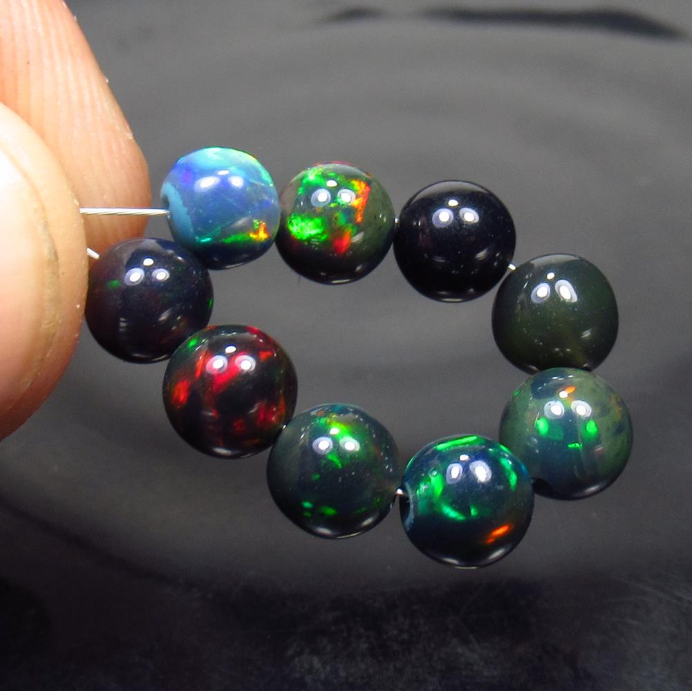 7.90 Ctw Natural 9 Drilled Black Fire Opal Ball Beads: No Reserve! Title: 7.90 Ctw Natural 9 Drilled Black Fire Opal Ball Beads Stone Clarity: Transparent Gemstone: Black Opal Beads Carat Weight: 7.90 Dimesnions: 5.80 - 6.00 mm / 9 Pcs Additional Informat