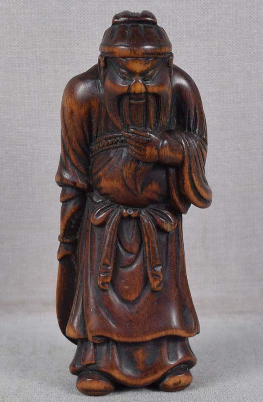 18c netsuke KWANYU hero / God of war: 18th century boxwood netsuke of standing Kwanyu holding a halberd in one hand and clutching his beard with the other. Kwanyu (Guandi in Chinese) is legendary and supposedly historical person, one of t