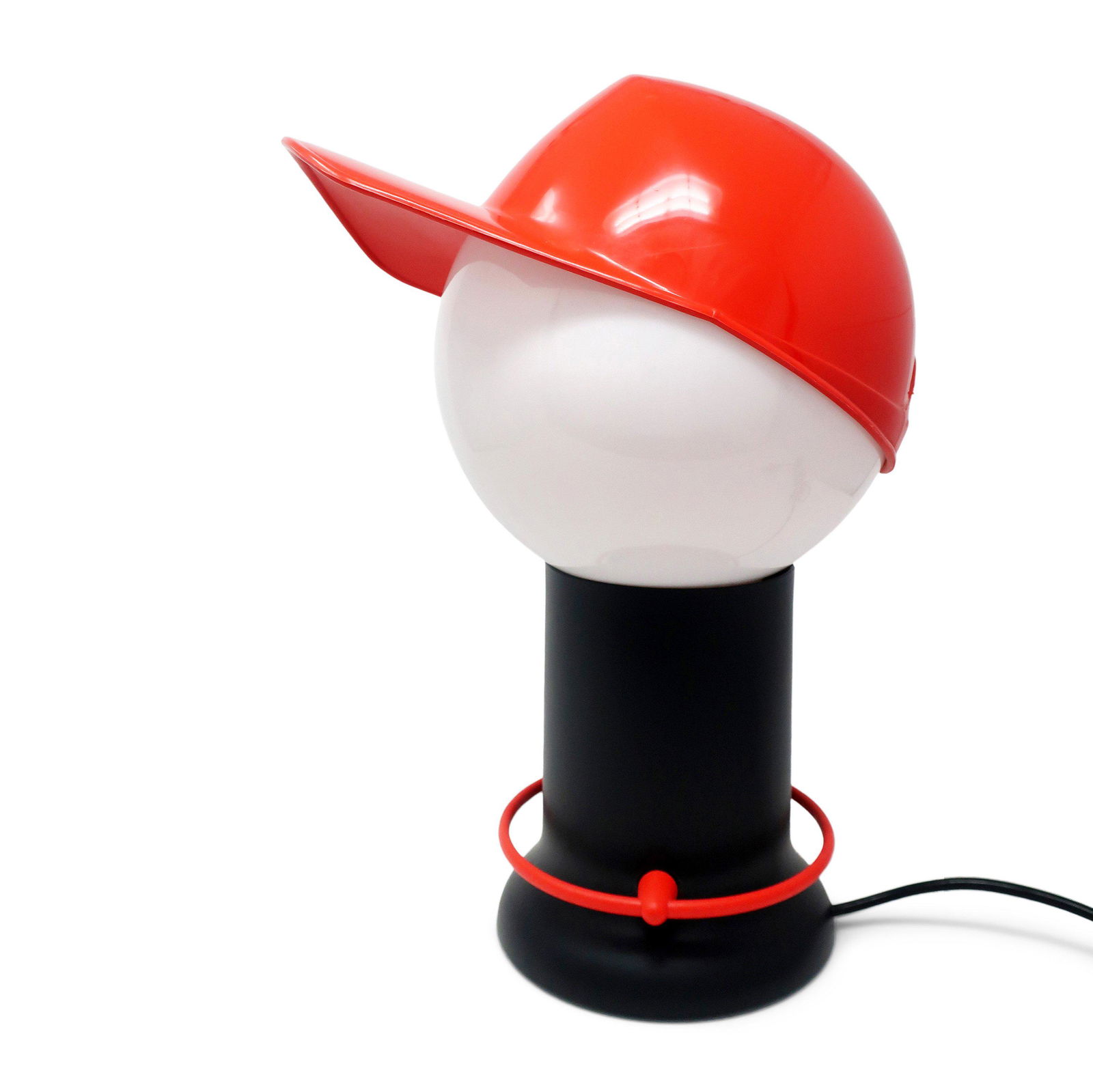 1980s Postmodern Baseball Cap Table Lamp by Giorgetto: A fantastic postmodern 1980s "Cap" table lamp by Giorgetto Giugiaro for Bilumen. A red baseball hat sits on a white globe shade, which in turn sits on the black base. On/off switch is a red plastic ci