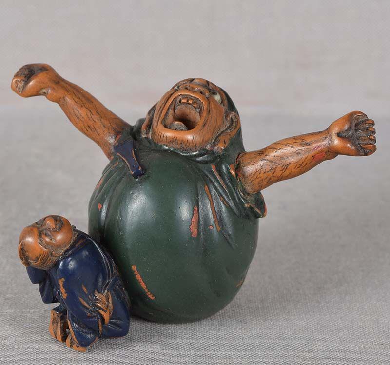 19c netsuke SCULPTOR & stretching DARUMA statue: 19th century lacquered and inlaid boxwood netsuke of a sculptor awed by his own work as he gazes up on a huge sculpture of Zen Buddhism patriarch Daruma yawning and stretching after 9 years of continu