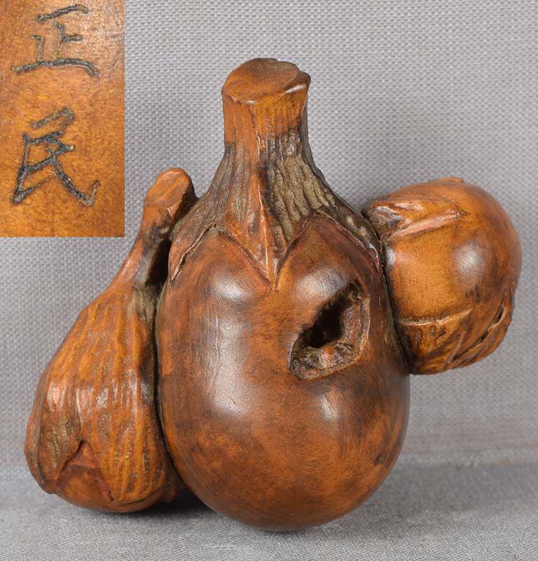Meiji burlwood netsuke 3 EGGPLANTS by MASAMIN: Late Meiji period wooden netsuke of three eggplants, the larger one containing anabori (cavern) carving of stylized landscape. The material is burl wood with nice play of colors. Very nice realistic c