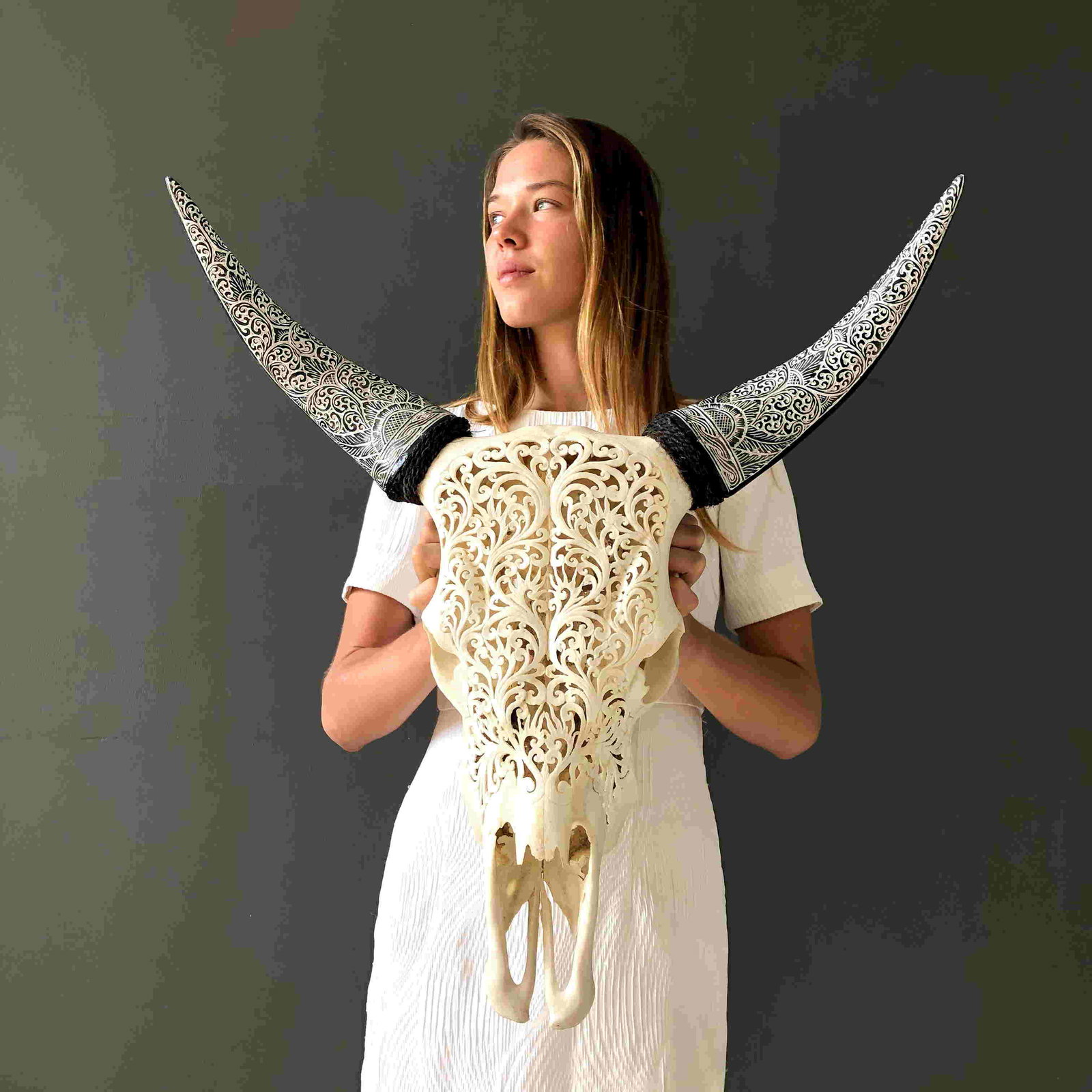 White Cow Skull with Bohemian Carved Horns -: Title: White Cow Skull with Bohemian Carved Horns - Traditional balinese motif Maker: Unknown Origin: Indonesia Date/Period: 2021 Materials: Bone, Bos Taurus Dimensions:H: 64 cm / 25.1 inches W:58.5 c