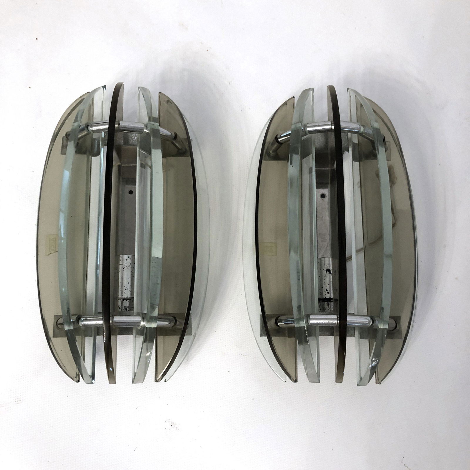 Veca, pair of Italian signed glass sconces from 60s: Material: glass, chrome Dimensions: H 28 W 17 D 11 (cm) This pair of glass and chrome sconces have been produced from the Italian Veca during the 60s. Very good vintage condition with trace of age and