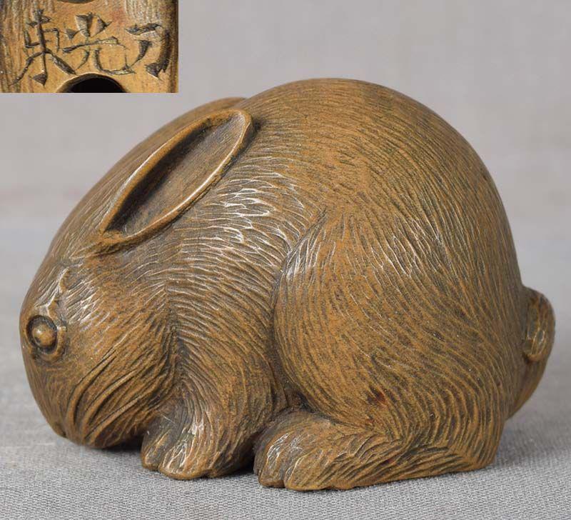 19c netsuke crouching Zodiac RABBIT by TOKO: 19th century wooden netsuke of a crouching fat rabbit. Wonderful Zodiac animal with alert face, its whiskers are carved in raised technique, excellent depiction of its body volume, finely carved coat,
