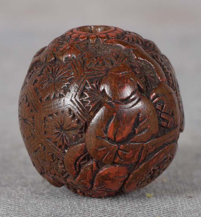 19c Japanese lacquer OJIME netsuke slide SCHOLAR in: 19th century lacquer ojime (slide bead for tightening the cord going from netsuke to inro) with low relief carving of a scholar seated in a cart, which is being pushed by his attendant through the gar