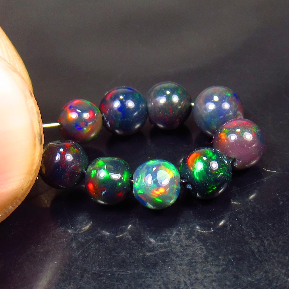 4.04 Ctw Natural 9 Drilled Black Fire Opal Ball Beads: No Reserve! Title: 4.04 Ctw Natural 9 Drilled Black Fire Opal Ball Beads Stone Clarity: Translucent Gemstones: Black Opal Beads Carat Weights: 4.04 Size/Dimensions: 4.30 to 5.00 mm / 9 PC's Additional