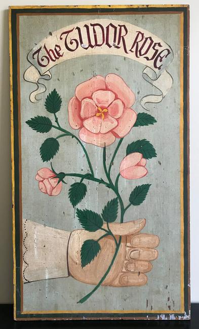 Graphic Advertising Sign: Title: Graphic Advertising Sign Provenance/Additional Info: "The Tudor Rose" wood painted sign featuring a colorful rose being grasped by a hand dressed in a dapper cuffed shirt. It dates from the mid
