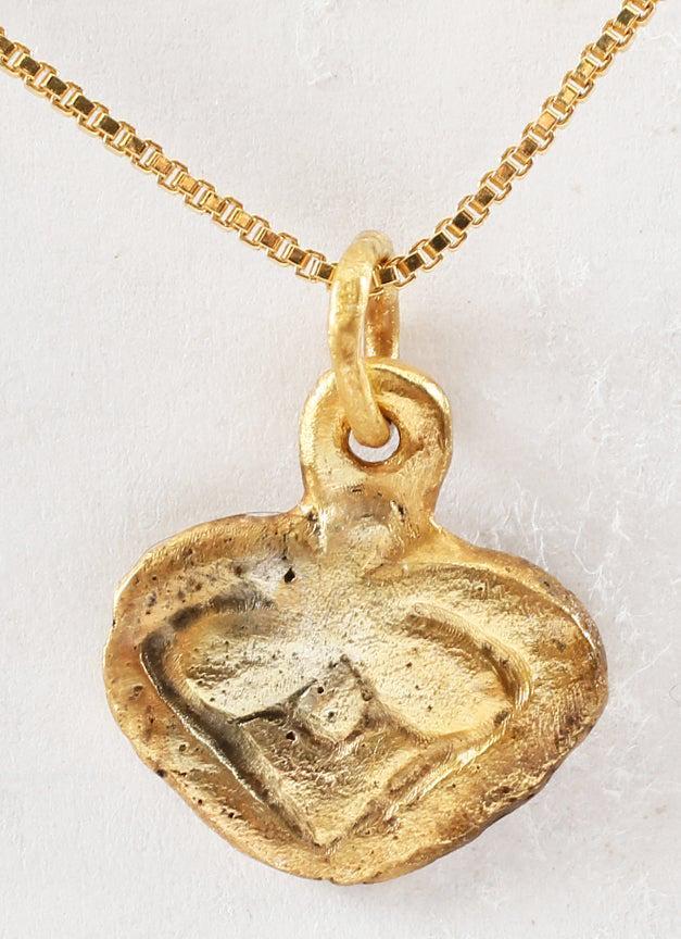 VIKING HEART PENDANT NECKLACE C.850-1050 AD: Gilt bronze. 0.57" width (under 5/8"). Flat form with broad edges, the cusp terminals evolving into the upper part of the enclosed trefoil. Made by the open face mold technique. The heart stood for br