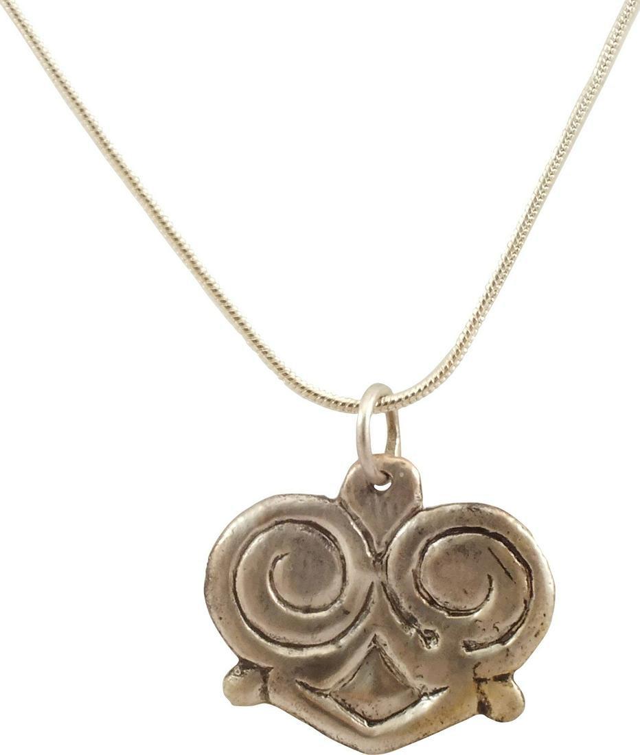 VIKING HEART PENDANT NECKLACE, C.850-1050 AD: Slightly under 1" width of fully evolved cusped top heart form. Broad-line border scrolling to for the cusp and the top of a trefoil, completed by an angular terminal. Lower quartered nubs. The form i
