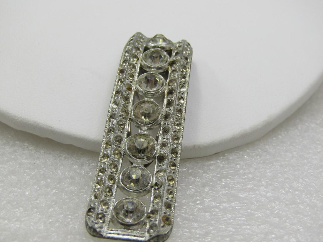Vintage Art Deco Rhinestone Dress Clip 1920's-1930's.: Vintage Rhinestone Dress Clip 1920's-1930's. 2-3/8"-5/8". Sloped with a slight curve with 6mm round stones done the center and 2mm down the sides. There are two rows one ach side, one on the outer edg