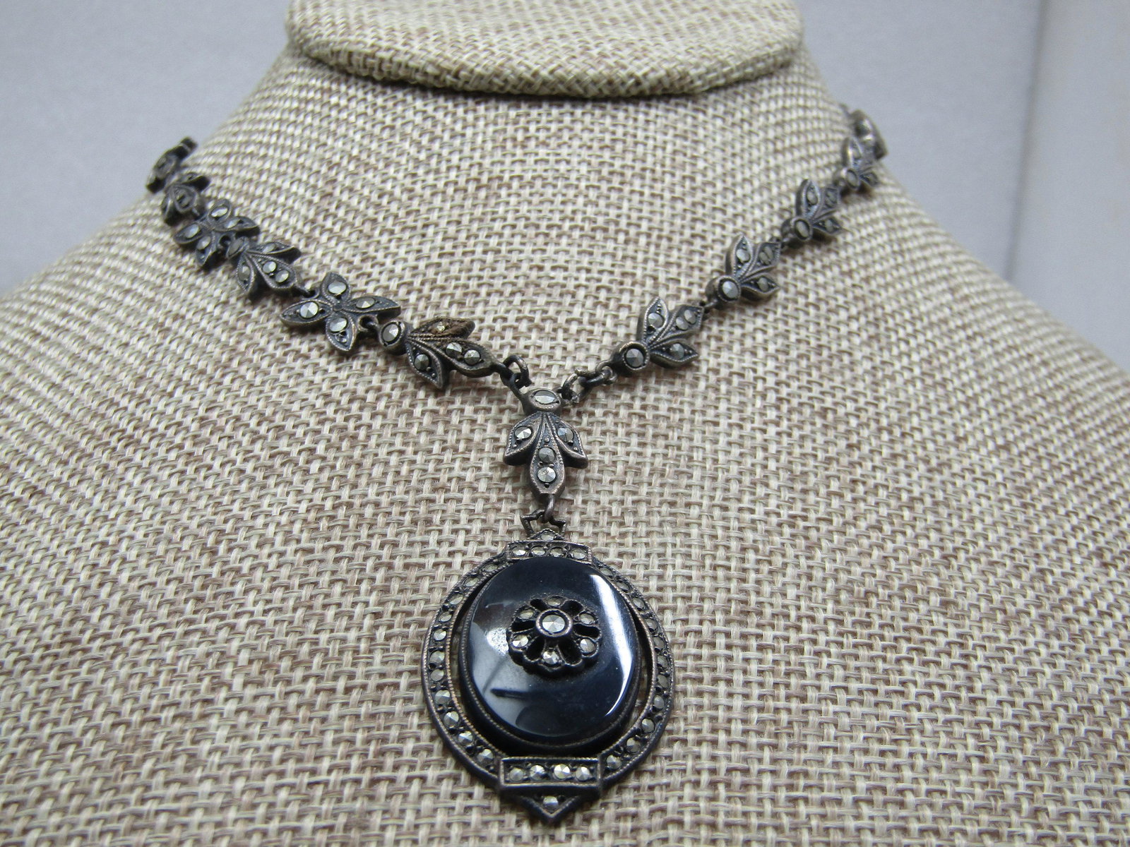 Antique 1920's Sterling Onyx Marcasite Necklace: Antique 1920's Sterling Onyx Marcasite Necklace, Lavalier, 16.5". This has a leaf-like Art deco design for the chain that has marcasites through with a lavalier drop pendant that is 2" including the m