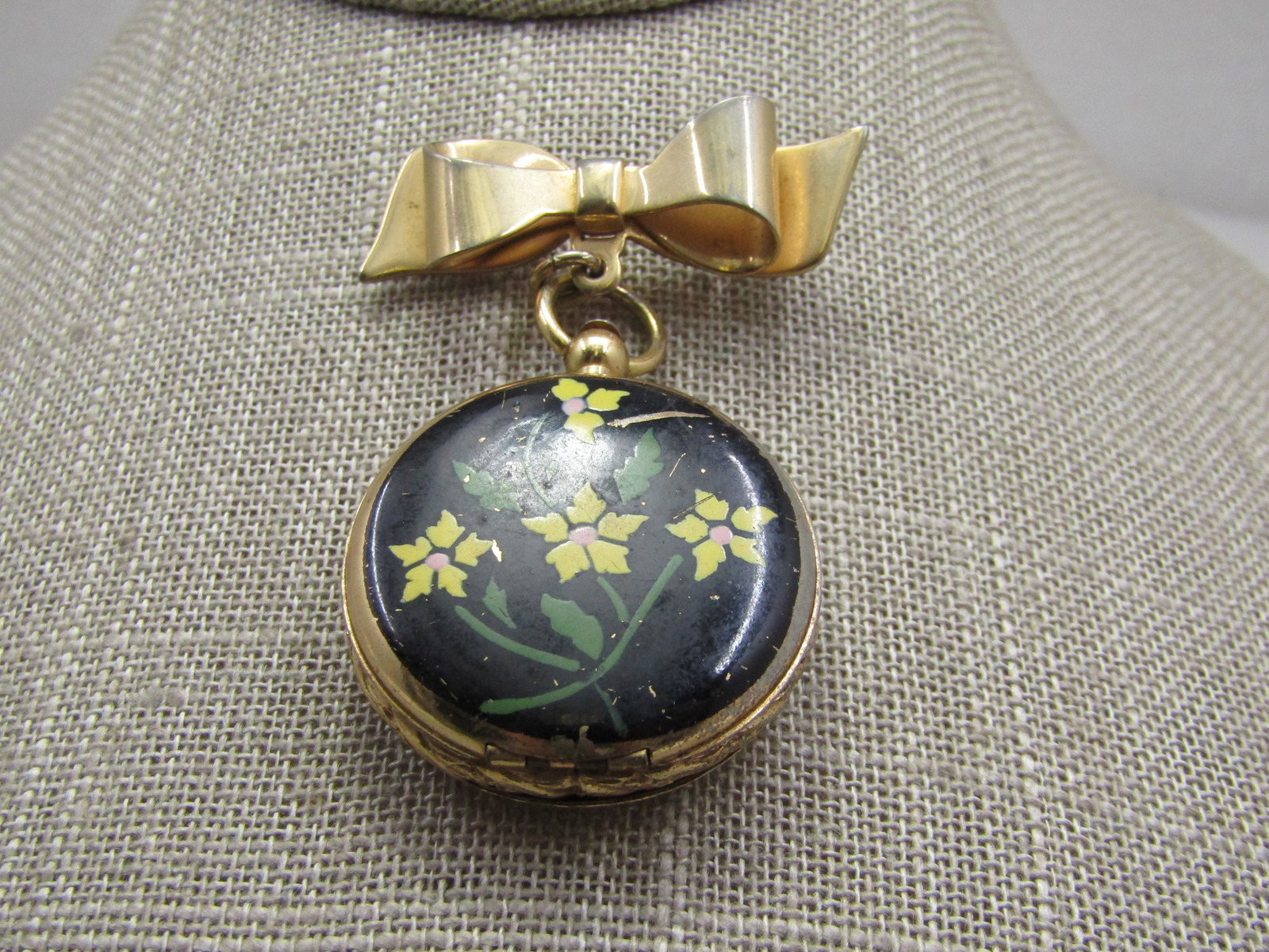 Vintage Floral Enameled Locket with Bow Brooch 1940's: Vintage Floral Enameled Locket with Bow Brooch, 1940's. It is appx. 2.25" from top of the bow to the bottom of the locket. Black background with yellow flowers and green stems and leaves, locket is ap