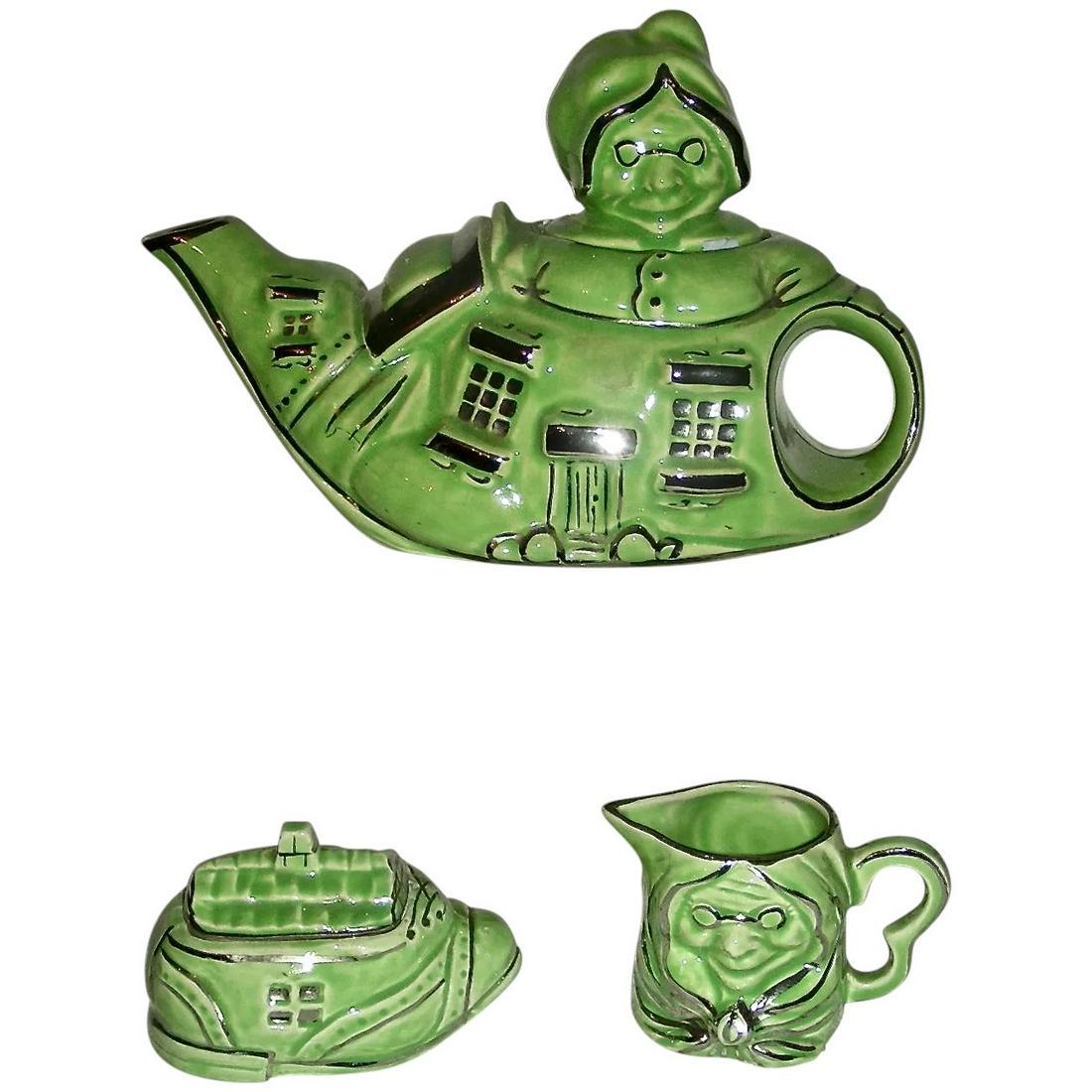 Lingard "Old Lady in a Shoe" Tea Set, Early 20th C.: A novelty tea set (teapot, sugar bowl and cream pitcher) by Lingard Pottery of England in the form of a shoe house with the Old Lady's head serving as the teapot lid. Lingard is known for its whimsica