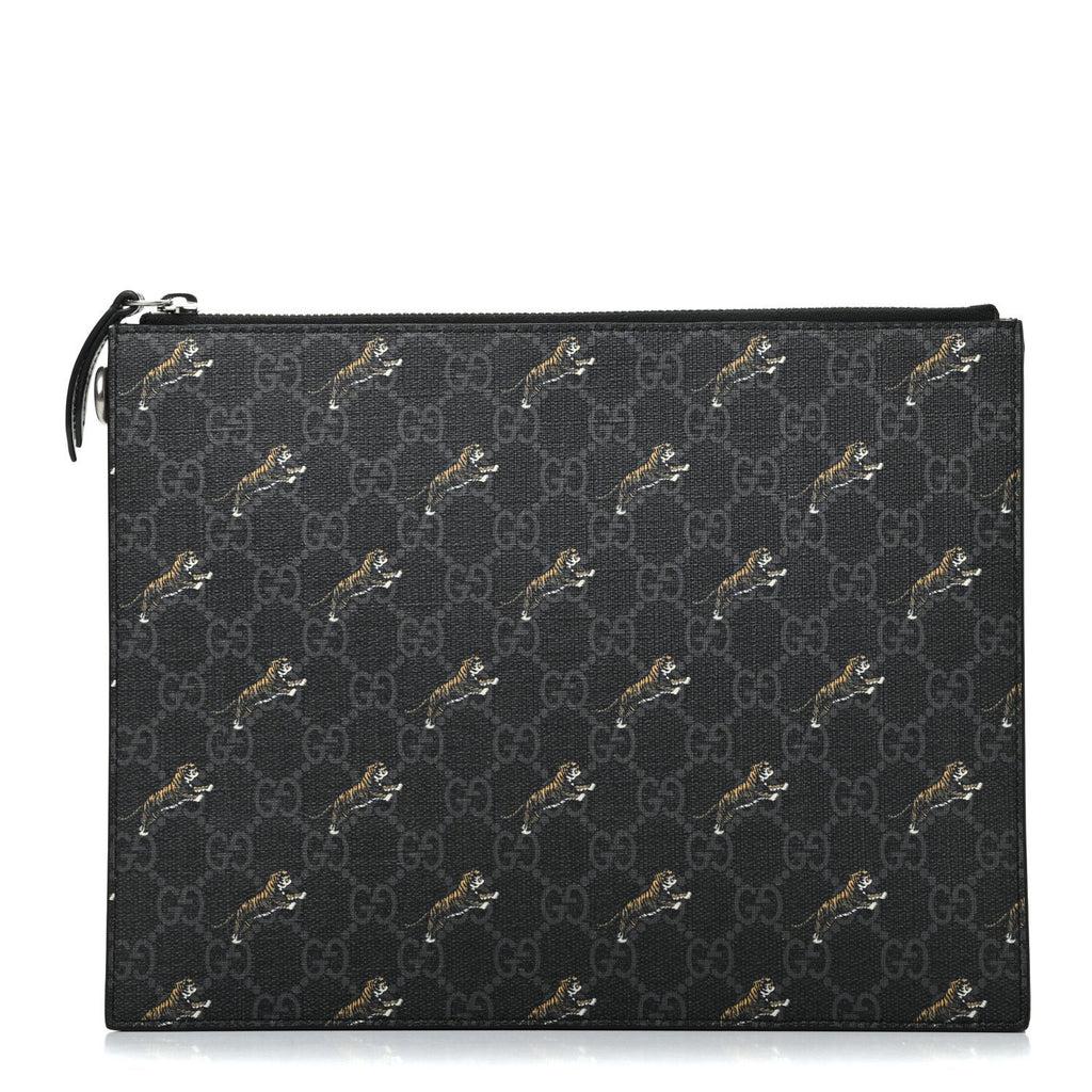 Gucci Black GG Supreme Monogram Tiger Print Pouch: This clutch from Gucci is the perfect accessory to complete any outfit. It is crafted with a tiger printed Guccisima Supreme Canvas and black leather details. There is a detachable wristlet strap and