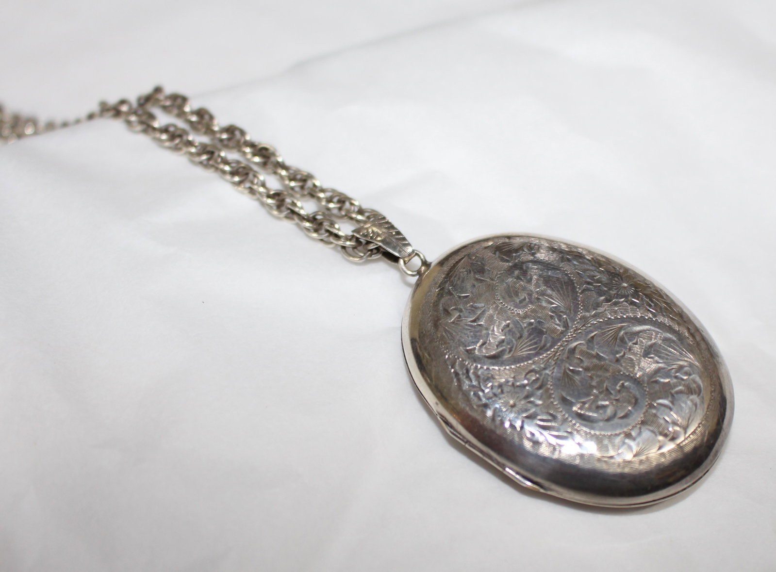 Vintage Engraved Silver Locket on Chain: Vintage Engraved Silver Locket on Chain Sterling silver, fully hallmarked Locket measures 3.7 x 4.7 cm Chain length: 68 cm / 26 3/4 in Total weight: 36.9 g Good vintage condition Reserve: </