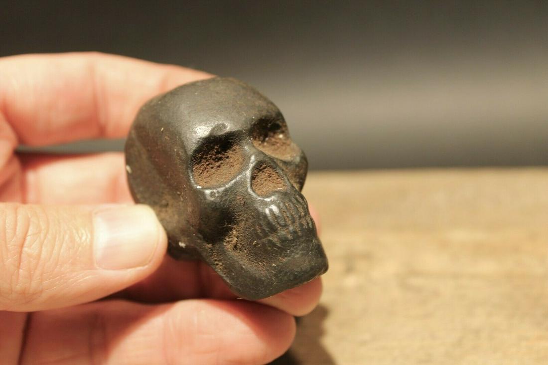 Miniature Cast Iron Skull Paperweight: 2" L x 1 1/4" W Such neat reproduction antique cast iron skull paperweight. Surprisingly heavy at 8.4 oz ..just over half a pound. Such a small solid piece. The natural dark brown patina makes it look