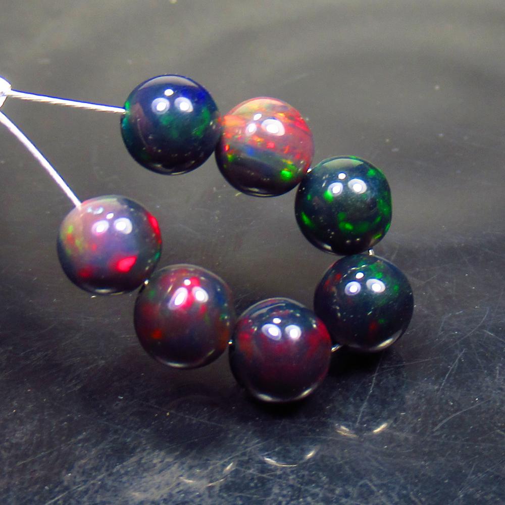 6.23 Ct Natural 7 Drilled Black Fire Opal Ball Beads: Title: 6.23 Ct Natural 7 Drilled Black Fire Opal Ball Beads Stone Clarity: Translucent Gemstones: Natural Black Opal Beads Carat Weights: 6.23 Size/Dimensions: 5.90 to 6.10 mm / 7 PC's Additional Info