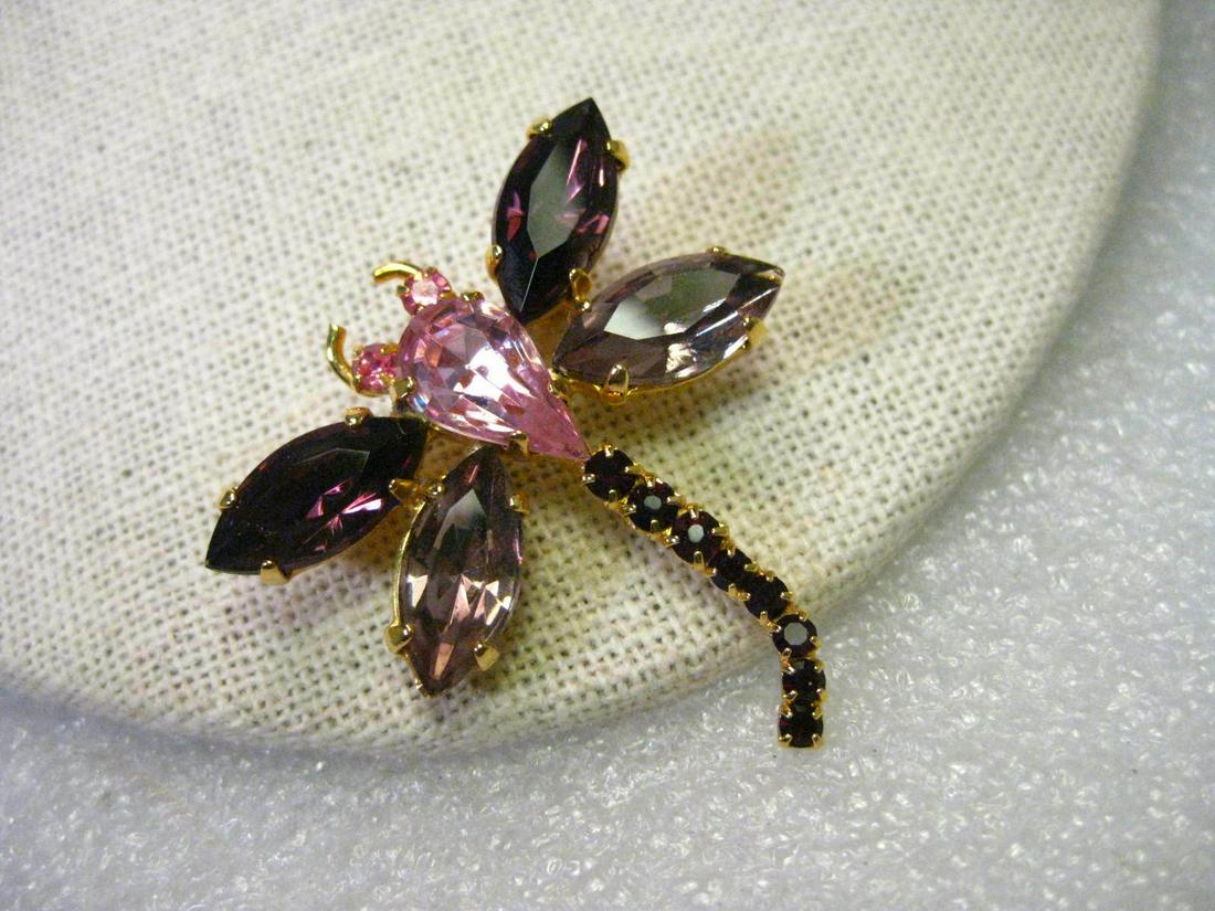 Vintage Gold Tone Merlot & Pink Dragonfly Brooch, Glass Rhinestones, 1.5": Vintage Gold Tone Dragonfly Brooch in shades of pink and merlot glass rhinestones. This is about 1.5" tall and slightly less from wing-to-wing. It has large marquis stones for the wings and an inverte
