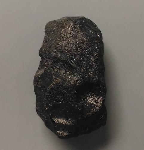 PHILIPPINITE TEKTITE - FROM METEORITE IMPACT: Title: PHILIPPINITE TEKTITE - FROM METEORITE IMPACT Origin: Paracale, Camarines Norte, Luzon, Philippines Size: 2x1x1 cm / 3 gram Description: small curved philippinite tektite with deep pits. some ti