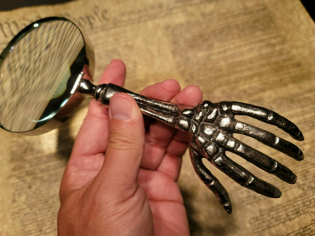 Skeleton Magnifying Glass Desk Hand Lens: 9 1/2" Long x 4" Wide Such a neat reproduction antique skeleton magnifying glass. The skeleton handle is all metal and aged to look old. The magnifying glass functions as it should. Makes a great acce