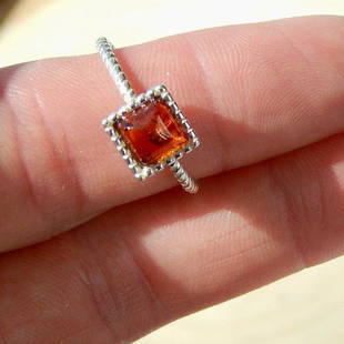 Genuine Baltic Cognac Amber Cushion Cut Ring: 100% Genuine cognac amber cushion cut 925 silver ring Size 6.75 Silver band has a braided look Cognac amber is brilliant with small air bubbles in it that reflect light Amber was mined in the Ukraine