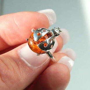 Genuine Cognac Amber Lady Bug Ring in 925 Silver: New in box Baltic amber lady bug ring 925 sterling silver design Polished natural Ukrainian amber Designed in Ukraine and made in Poland Size 6 Reserve: $30.00 Shipping:Domestic: Flat-rate of
