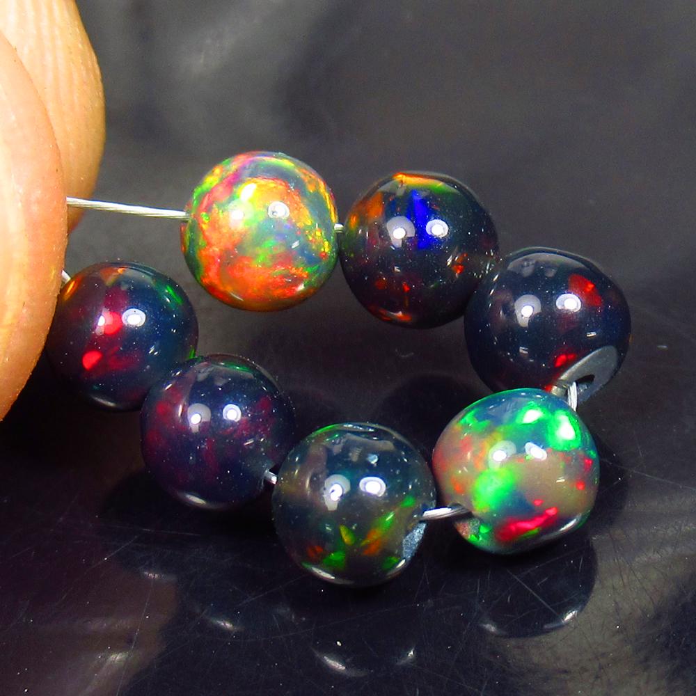 3.54 Ctw Natural 7 Drilled Black Fire Opal Ball Beads: No Reserve! Title: 3.54 Ctw Natural 7 Drilled Black Fire Opal Ball Beads Stone Clarity: Translucent Gemstones: Black Opal Beads Carat Weights: 3.54 Size/Dimensions: 4.60 to 5.10 mm / 7 PC's Additional