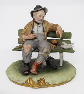 Capodimonte Tramp on Bench by B.Merli: Capodimonte Tramp on Bench by Bruno Merli Made in Italy, c.1970. Finely modelled with lots of detail; richly hand painted. Measures 24 x 20 x 22 (height) cm Good condition Reserve: