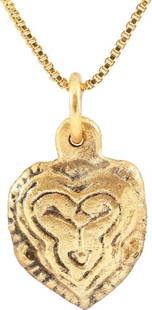 FINE VIKING HEART PENDANT, 10TH - 11TH CENT. AD: Just under 1/2" width. Broad heart of cusped form and domed section. The back hollow, perhaps for a keepsake. The central stylized trefoil with double incised borders and beaded outer edge. Made by
