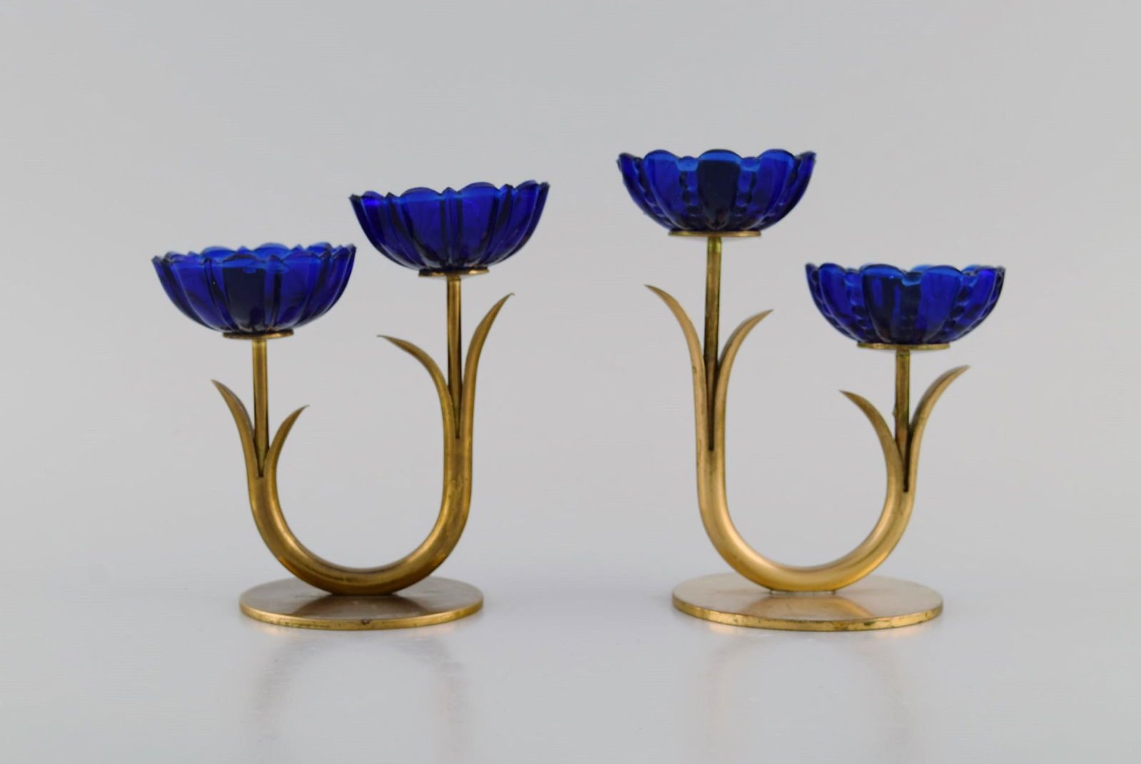 Gunnar Ander for Ystad Metall. Two candlesticks in brass and blue art glass shaped like flowers.: Title: Gunnar Ander for Ystad Metall. Two candlesticks in brass and blue art glass shaped like flowers. 1950s. Brand: Various Additional Information: Gunnar Ander for Ystad Metall. Two candlesticks in