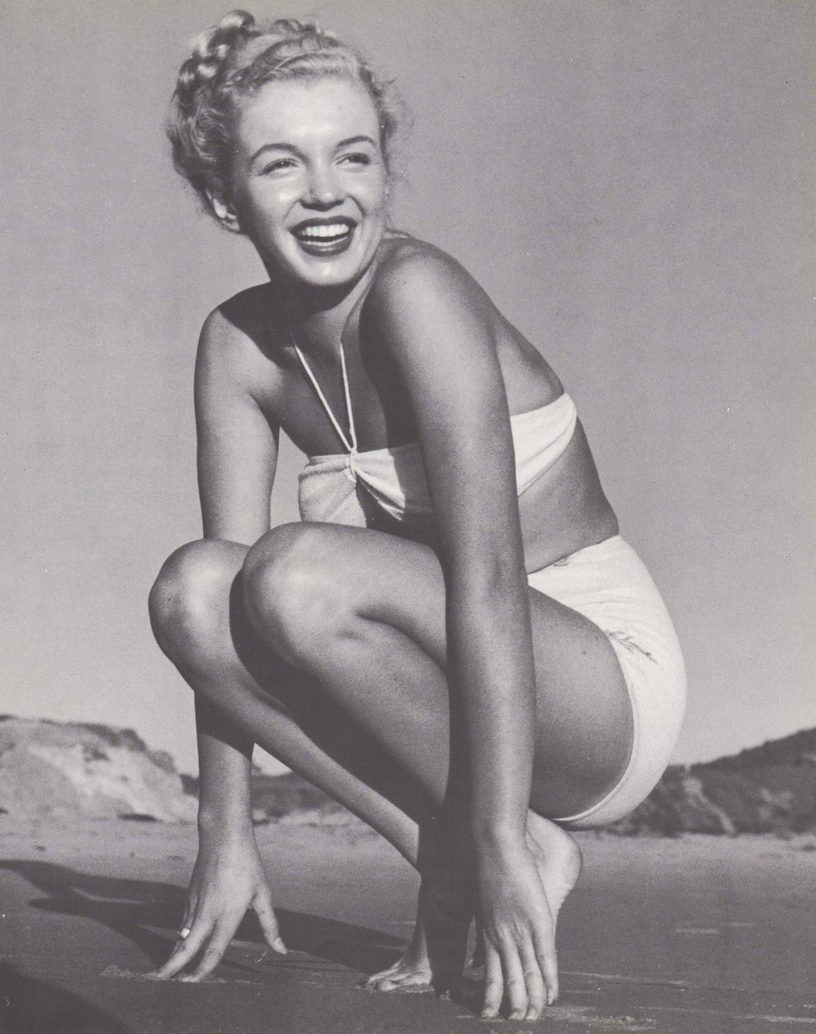 ANDRE DE DIENES - Marilyn Monroe (Norma Jean) on the beach (squatting): Artist: ANDRE DE DIENES Print Title: Marilyn Monroe ( Norma Jean) on the beach (squatting) Medium: Photo-lithograph Printed 1980’s in the USA Image size (inches) approx. 12 x 9” Andre De D