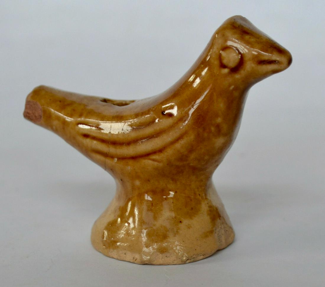 Yelloware Pottery Bird Whistle: Yelloware pottery bird whistle, circa 19th Century. Modelled from buff/yellow clay, with incising to indicate eyes, mouth and feathers. Glazed in an attractively blotchy amber, which only partially co