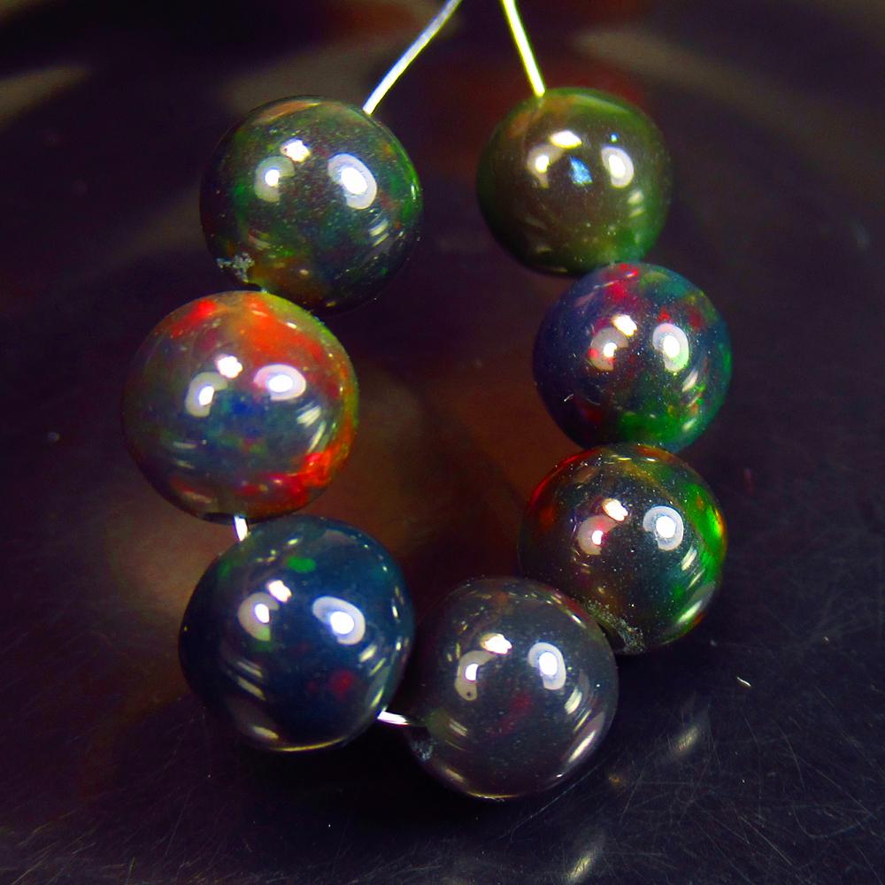 7.74 Ctw Natural 7 Drilled Black Fire Opal Ball Beads: No Reserve! Title: 7.74 Ctw Natural 7 Drilled Black Fire Opal Ball Beads Stone Clarity: Translucent Gemstones: Black Opal Beads Carat Weights: 7.74 Size/Dimensions: 6.20 - 6.40 mm / 7 Pc's Additional 