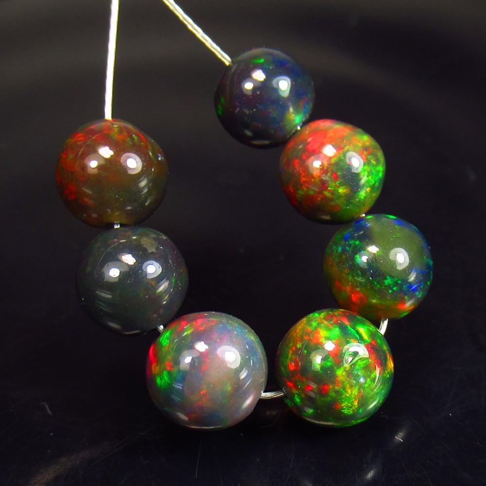 5.96 Ctw Natural 7 Drilled Black Fire Opal Ball Beads: No Reserve! Title: 5.96 Ctw Natural 7 Drilled Black Fire Opal Ball Beads Stone Clarity: Translucent Gemstones: Black Opal Beads Carat Weights: 5.96 Size/Dimensions: 5.20 to 6.00 mm / 7 PC's Additional