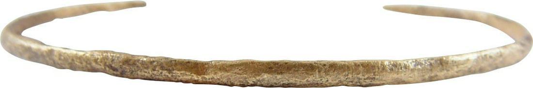 VIKING WOMAN'S BRACELET, C900-1050 AD: Well over 2 1/2" inside dimension which easily fits an average woman. C form, tapered from its center to the ends. Gilt bronze, narrow rounded section with slightly tapering ends. Surface textured fro