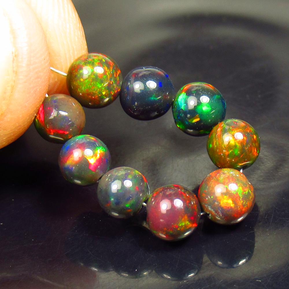 7.00 Ctw Natural 9 Drilled Black Fire Opal Ball Beads: No Reserve! Title: 7.00 Ctw Natural 9 Drilled Black Fire Opal Ball Beads Stone Clarity: Transparent Gemstones: Black Opal Beads Carat Weights: 7 Size/Dimensions: 5.00 - 5.70 mm / 9 Pcs Additional Info