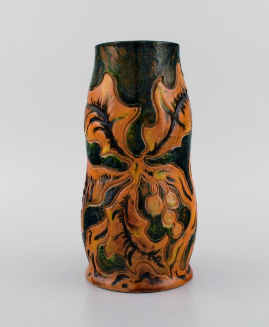 Michael Andersen, Denmark. Art nouveau vase in glazed ceramics with hand-painted foliage in brown: Michael Andersen, Denmark. Art nouveau vase in glazed ceramics with hand-painted foliage in brown and orange shades. 1920s / 30s. Measures: 21.2 x 11 cm. In excellent condition. Stamped. Reserve: $294