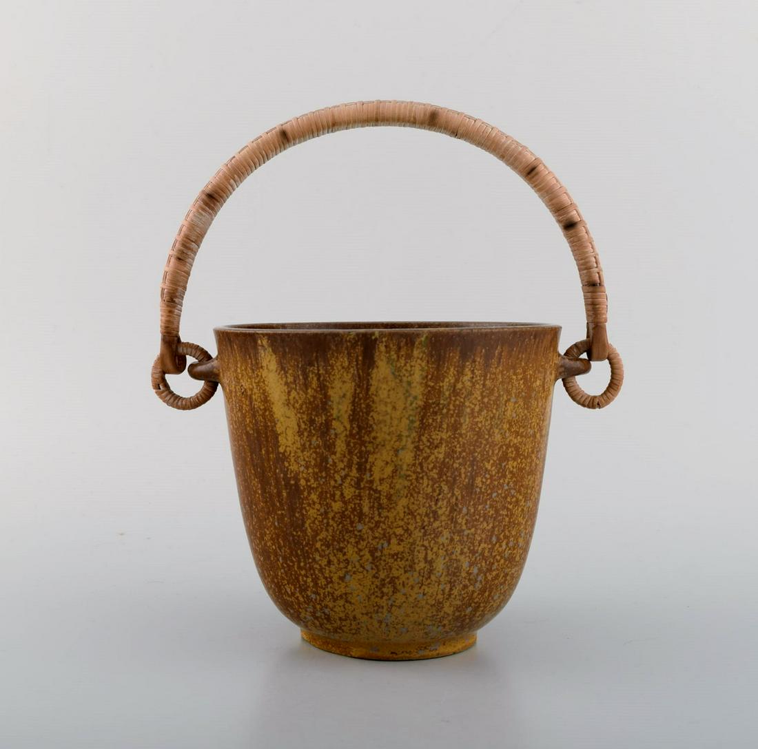Arne Bang (1901-1983), Denmark. Ice bucket in glazed ceramics with handle in wicker. Model number: Arne Bang (1901-1983), Denmark. Ice bucket in glazed ceramics with handle in wicker. Model number 15. 1940s / 50s. Measures: 23 x 20 cm (inc. handle). In excellent condition. Signed. Reserve: $938.00