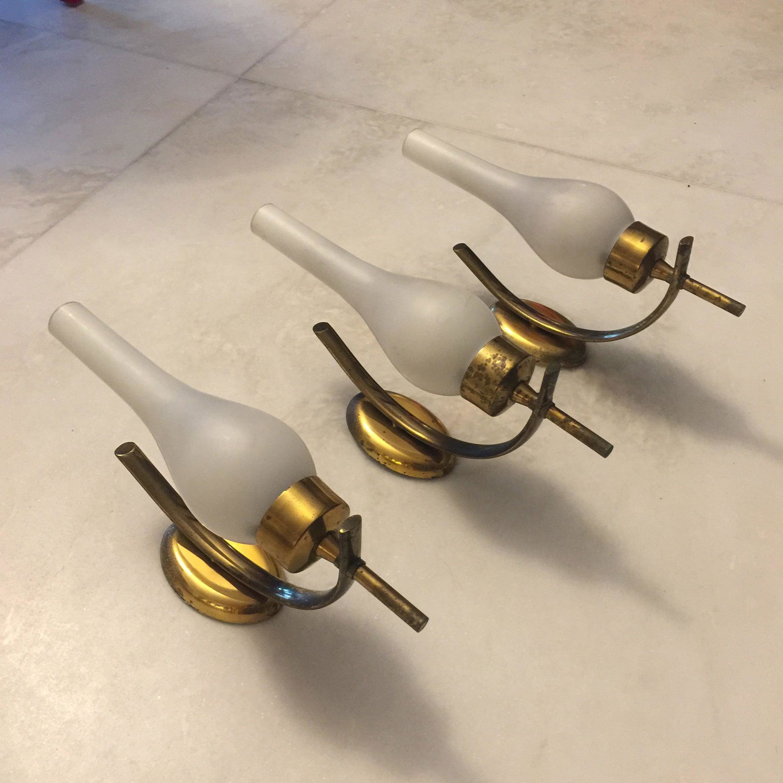 Set of Three Italian Brass and Opaline Glass Sconces, Arredoluce Style, 1950s: This set of three sconces was produced in Italy during the 1950s. Brass with original patina and opaline glasses. "Materials: brass and opaline glass Dimensions: 32 cm of height, 8 cm of length, 16 cm