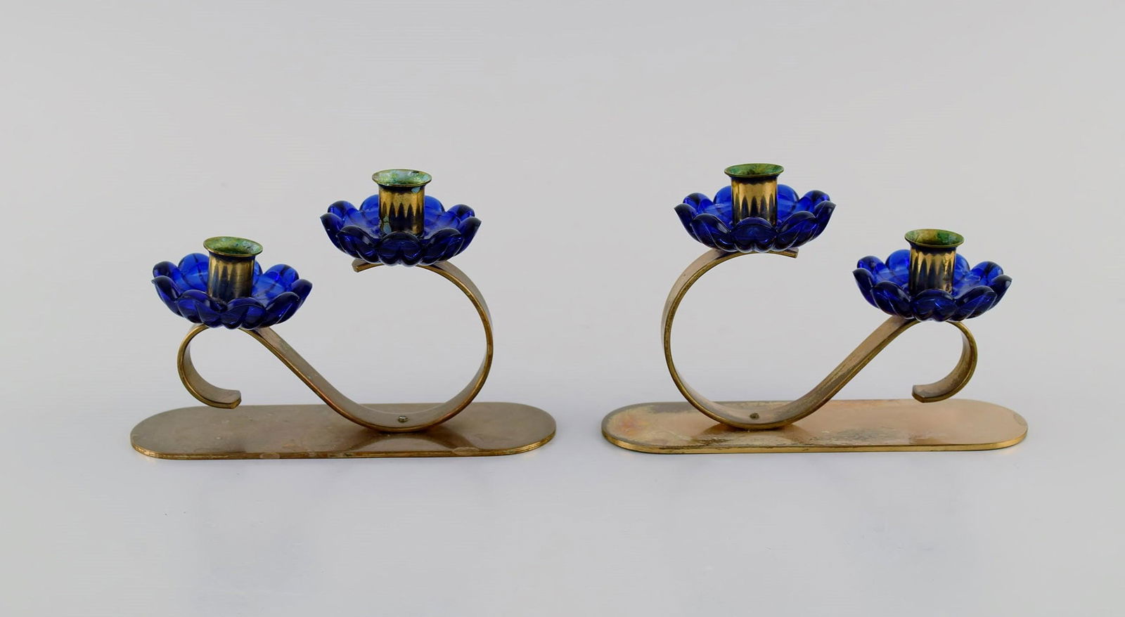 Gunnar Ander for Ystad Metall. Two candlesticks in brass and blue art glass shaped like flowers.: Gunnar Ander for Ystad Metall. Two candlesticks in brass and blue art glass shaped like flowers. 1950s. Measures: 12.5 x 3.8 cm. Height: 8 cm. In excellent condition. Reserve: $210.00 Shipping: Domest