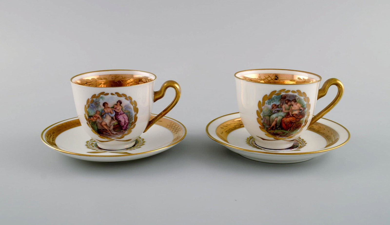 Two Royal Copenhagen coffee cups with saucers decorated with flowers and romantic scenes. Gold: Two Royal Copenhagen coffee cups with saucers decorated with flowers and romantic scenes. Gold decoration. Mid-20th century. The cup measures: 8 x 6.5 cm. Saucer diameter: 13.3 cm. In excellent condit
