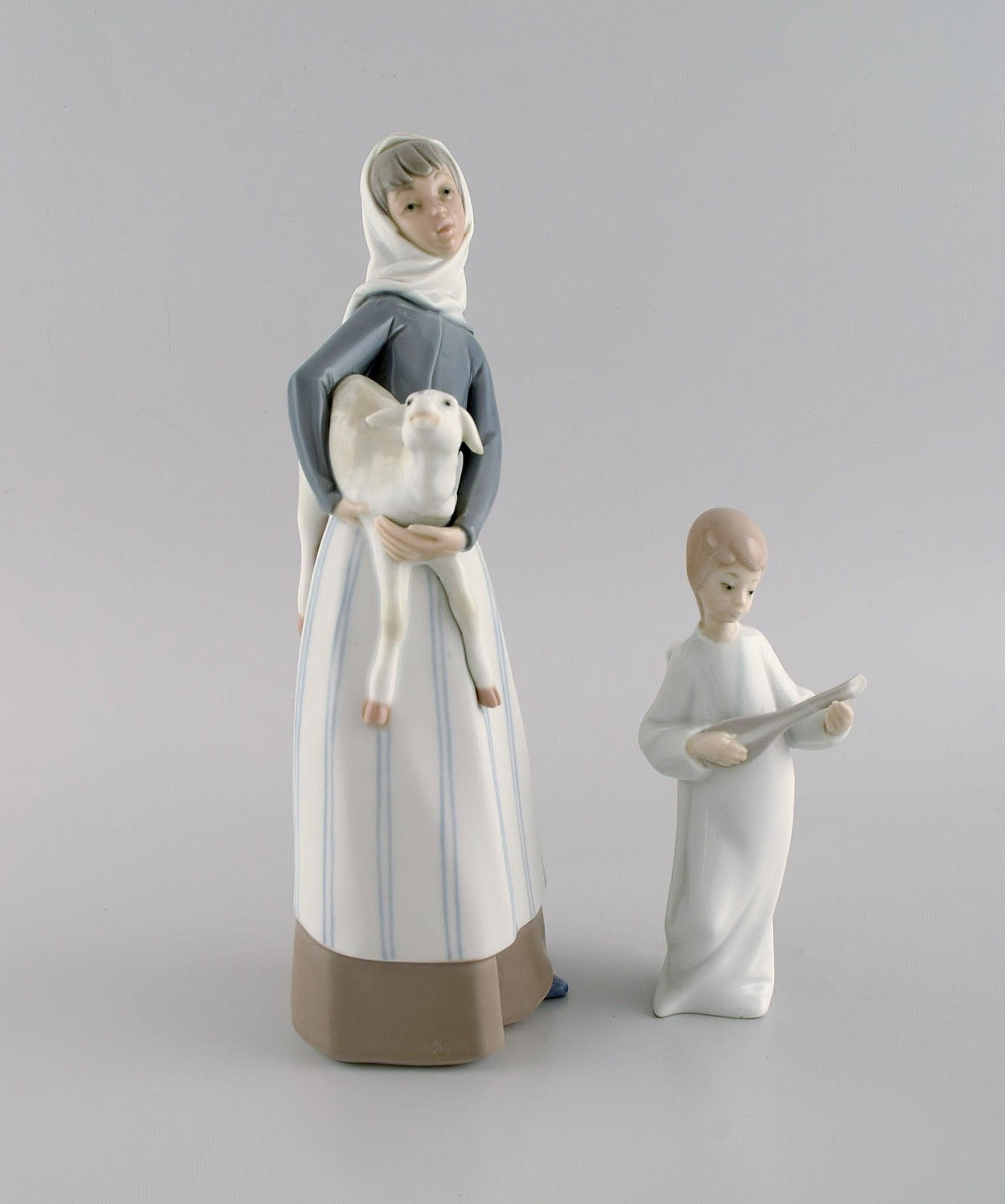 Lladro and Nao, Spain. Two porcelain figurines. Girl with lamb and angel boy. 1970s / 80s.: Lladro and Nao, Spain. Two porcelain figurines. Girl with lamb and angel boy. 1970s / 80s. Largest measures: 27.5 x 12 cm. In excellent condition. Stamped. Reserve: $175.00 Shipping: Domestic: Shippin
