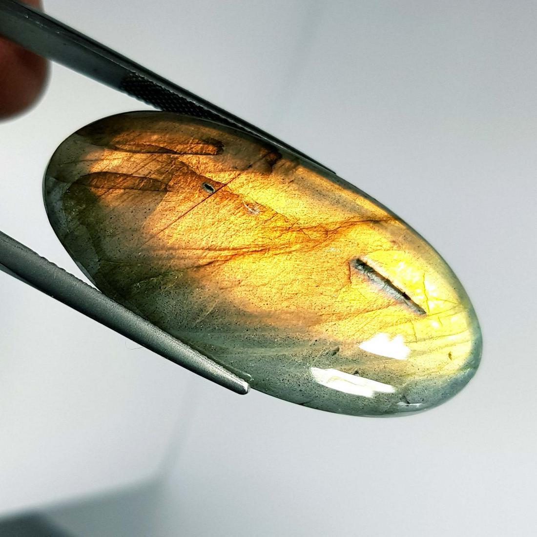 52.35 Ctz Natural Labradorite: No Reserve! Title: 52.35 Ctz Natural Labradorite Color/Clarity: Orange/ Semi Transparent Gemstones: Labradorite Carat Weights: 52.35 Size/Dimensions: 42.60 x 21.40 x 6.90 Additional Information: Oval