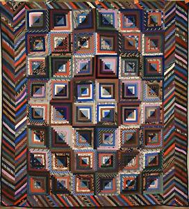 1870's Log Cabin Quilt, Chevron Border: This BEAUTIFUL wool 1870's barn raising log cabin quilt is all hand pieced and hand quilted, with a piano key border on two sides. The log blocks have unusual black and blue triangles in the centers, 