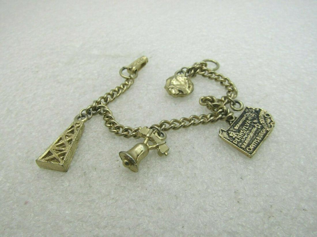 Vintage Pennsylvania Charm Bracelet, 7", Mid-Century: Vintage 1960's Pennsylvania Charm Bracelet, 7" with an oil tower charm, Liberty Bell, State Charm, and Gold Nugget, one other charm is missing. Curb Link chain that is appx. 4mm wide, flip clasp. 1950