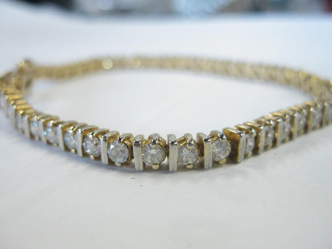 Vintage 1980's Goldtone 7.25" CZ tennis bracelet, 46 stones, hinged safety clasp: Vintage app. 1980's cz tennis bracelet, appx. 46 stones, all bright and clear separated by a goldtone accent bar. It is 7.25" long and 4mm wide. It has a slide-in clasp with two hinged safeties. Photo