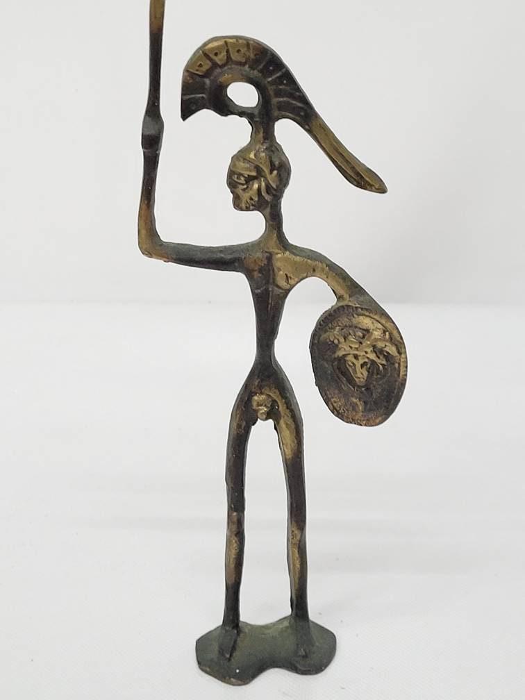 Vintage Bronze Statue Tall Skinny Sculpture Metal Table Art, Mythological God Nude Spear Shield: Vintage from the 1950s Materials: Medium: Bronze Width: 3.5 inches Height: 9.25 inches Description Naiv Bronze Sculpture of Poseidon, Mythological God Holding sword and shield Estimated from 1950's, i