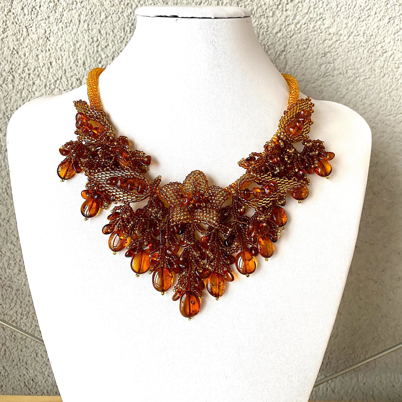 Stunning Amber Floral Necklace made from leaf like bead ornaments: Title: Stunning Amber Floral Necklace made from leaf like bead ornaments Metal: None Gemstones: Amber Weight: 63.4 g Size: Size: 480.0 x 70.0 x 15.0 mm Size: 18.898 x 2.756 x 0.591 inches Made of: Who