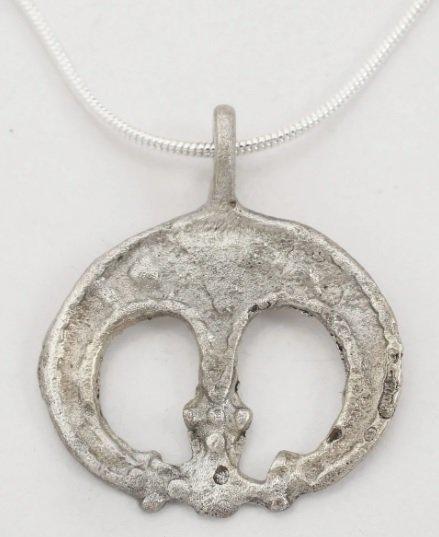 VIKING ASTROLOGICAL AMULET NECKLACE, 9th-10th CENTURY: Silvered bronze, 1” width. The crescent moon with the tips converging and each as three spheres. A further central projection with triple spherical terminal, joins the others to surround a large